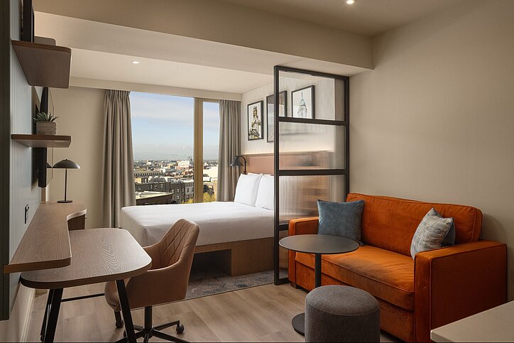 Die Queen Studio Suites des Home2 Suites by Hilton Dublin City Centre warten mit separiertem Ess-, Wohn- und Arbeitsbereich auf. © 2026 Hilton